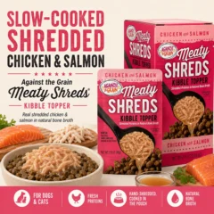 A bowl of dog kibble topped with Shreds Slow Cooked Shredded Chicken & Salmon Kibble Topper sits beside two boxes of the product, with key features listed below.