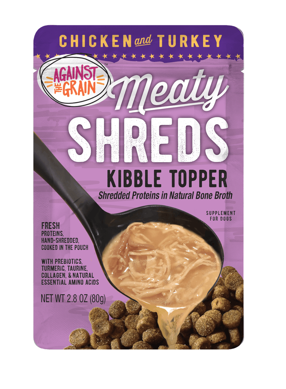 A pouch of Shreds Slow Cooked Shredded Chicken & Turkey Kibble Topper, featuring shredded meat in broth poured over dog kibble.