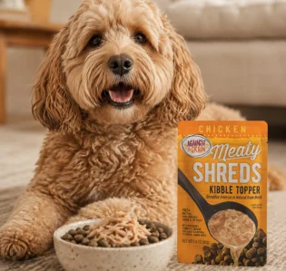A dog alongside a pouch of Against the Grain shreds.