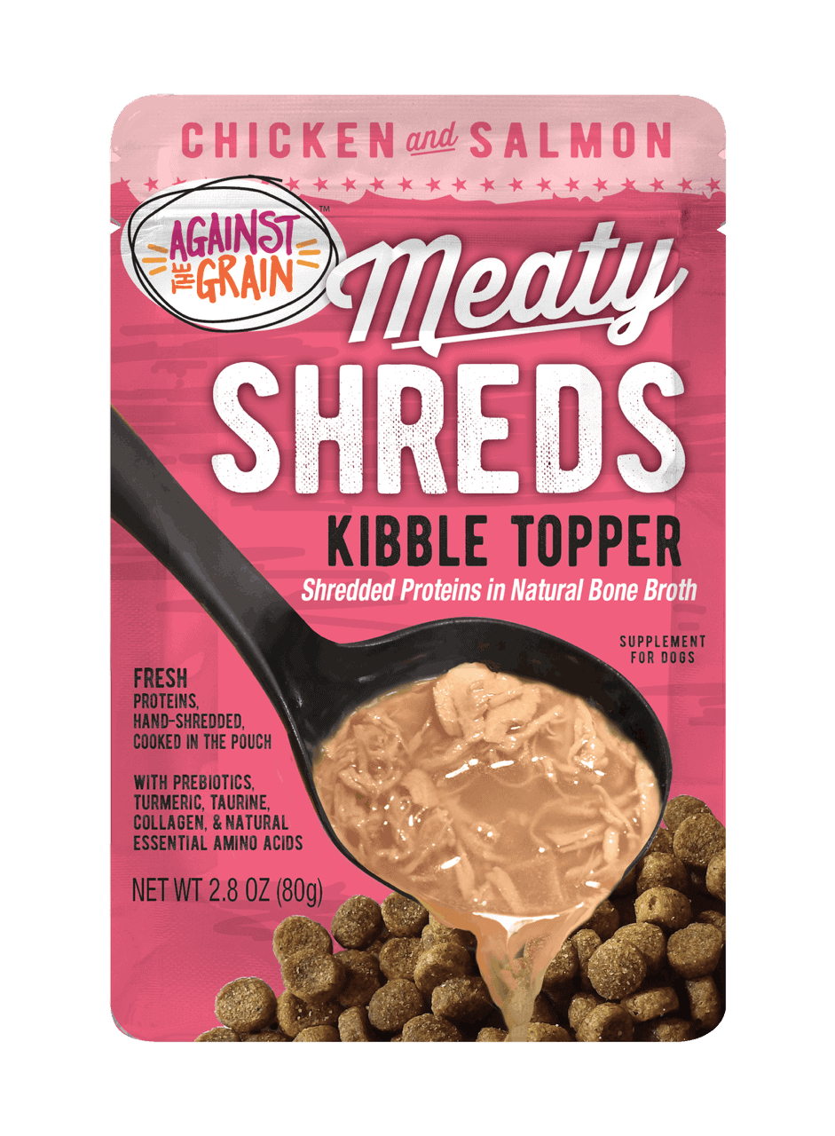 A pouch of Shreds Slow Cooked Shredded Chicken & Salmon Kibble Topper for dogs, showing shredded meat in broth being poured over kibble.